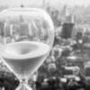 Hourglass with a city in the background. Article title: Understanding Guaranteed Lifetime Withdrawal Benefit Annuity Rider